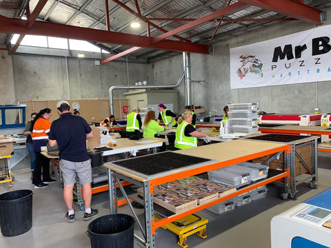 An internal photo of the Mr Bob Puzzles factory with various people working, wearing hi-vis shirts