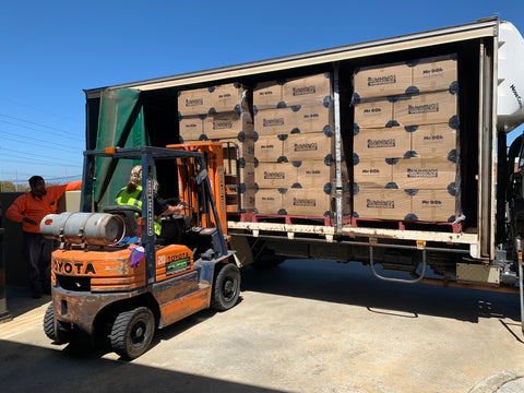 A photo of a forklift attempting to collect boxes from a truck or van